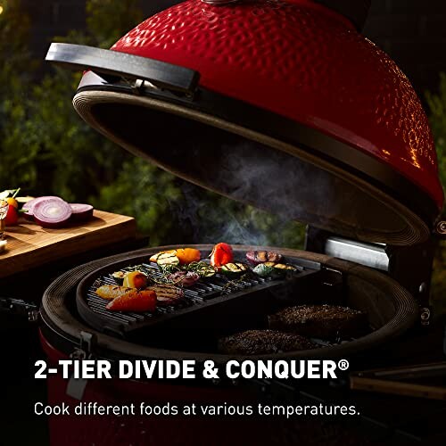 Kamado grill with assorted food cooking on two-tier grates