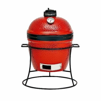 Red Kamado-style ceramic grill on a metal stand.